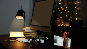 lamp shining on notebook near computer